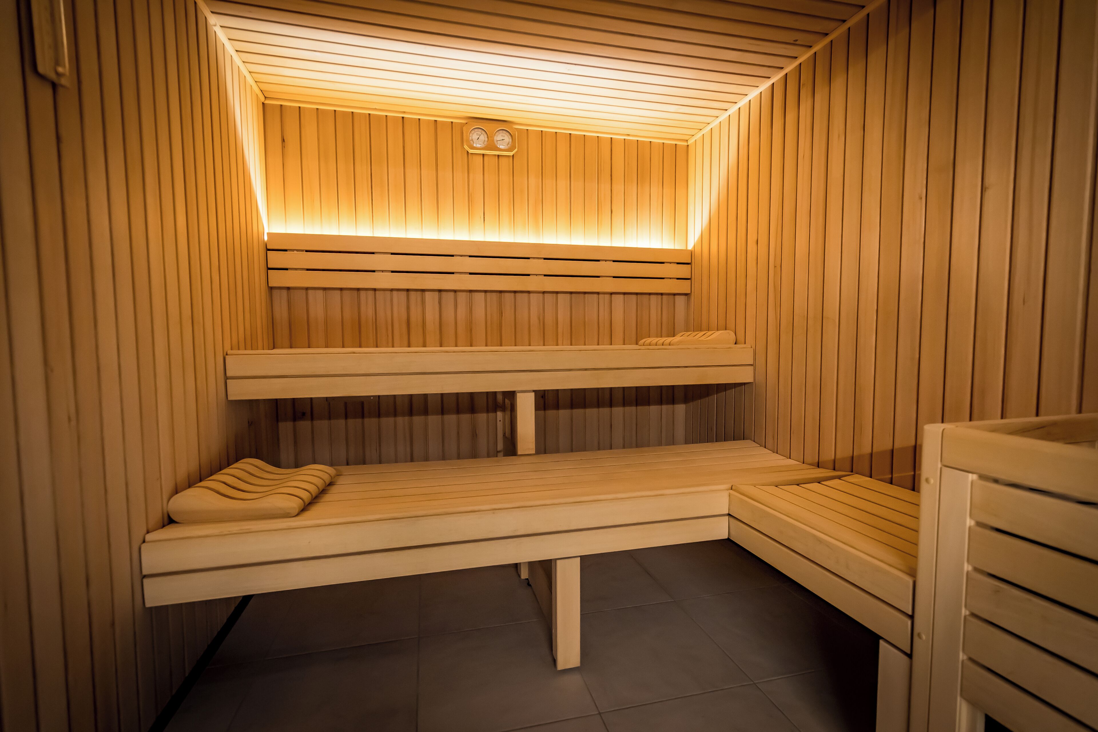 Eine Sauna mit Holzbänken und einer geneigten Decke.