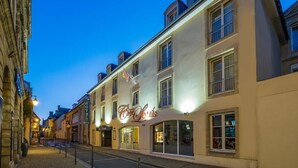 Un edificio con un letrero que dice "Cafe Louis" y un cartel de "Hotel" encima.