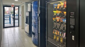 Ein Getränkeautomat mit Snacks und Wasserspender in einem Flur.