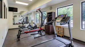 A gym with treadmills, exercise bikes, and a weight machine. There are large windows and a clock on the wall. - Comfort Suites Cordova (Cordova)