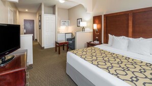 A hotel room with a bed, a TV, a desk, and a microwave. - Comfort Suites Cordova (Cordova)