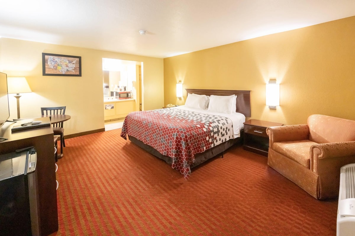 Quarto de hotel com uma cama, uma mesa, uma cadeira e um sofá.