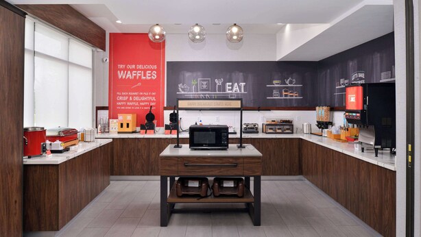 Una cocina moderna con una isla central, microondas y cafetera.