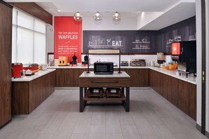 Una cocina moderna con una isla central, microondas y cafetera.