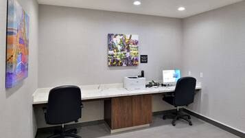A modern office space with two desks, chairs, and a computer.
