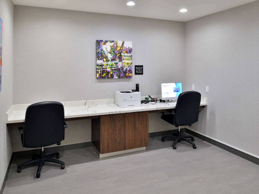 A modern office space with two desks, chairs, and a computer.