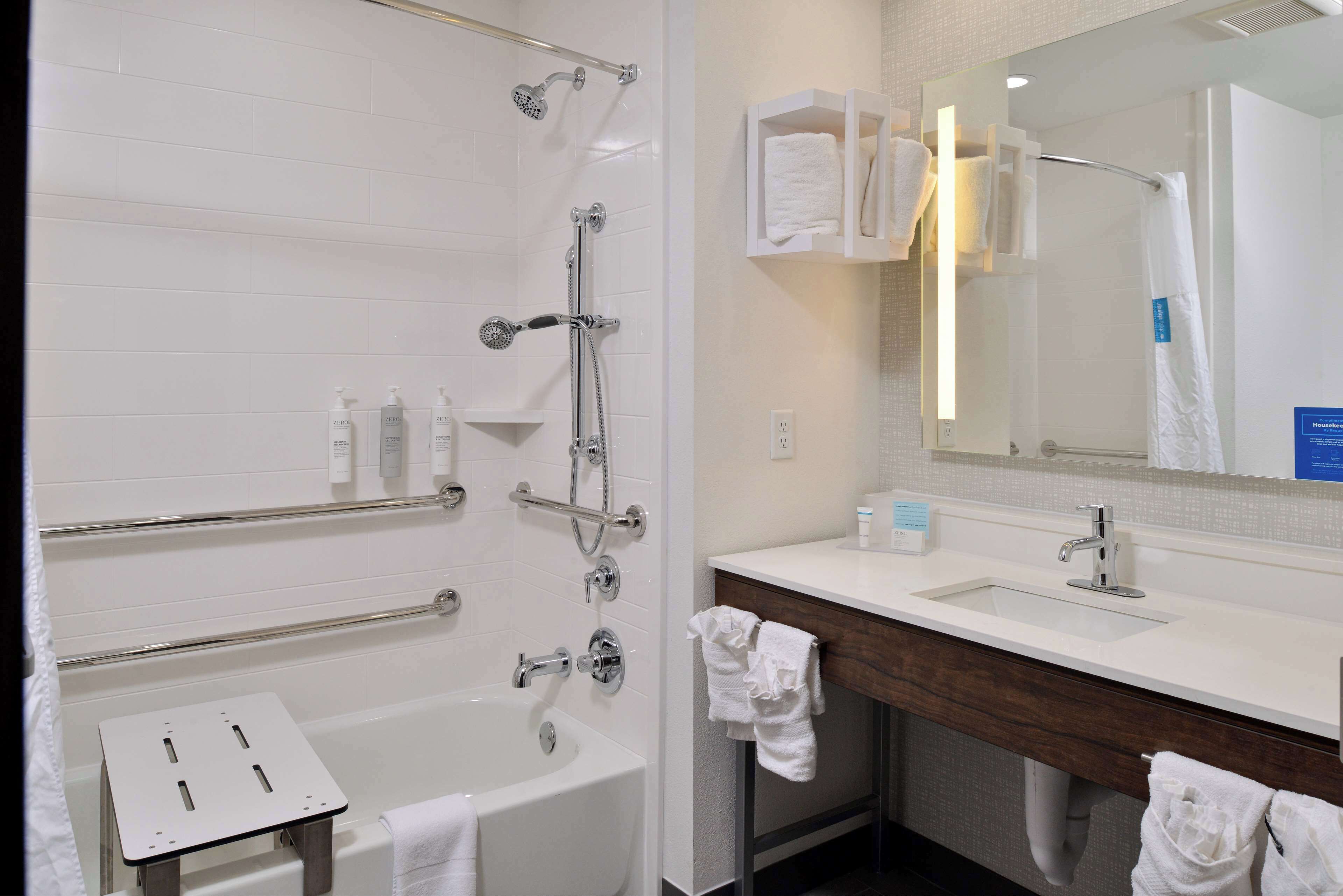 A modern bathroom with a bathtub, shower, and vanity.