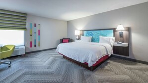 Une chambre d’hôtel moderne avec un grand lit, un bureau et une chaise.