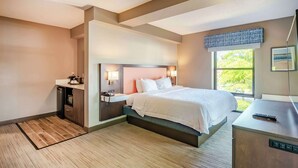 A modern hotel room with a large bed, bedside lamps, a desk, and a window with a view of greenery. - Hampton Inn Wilmington-Medical Park (Wilmington)