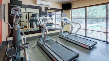 A gym with treadmills, a stationary bike, and a rowing machine.