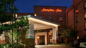A Hampton Inn hotel entrance with a brick facade and a neon sign. - Hampton Inn Wilmington-Medical Park (Wilmington)