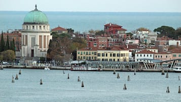 A coastal cityscape with a prominent historical building featuring a dome, a marina with boats, and a variety of residential and commercial buildings.