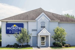A Microtel Inn & Suites building with a gabled roof, a front entrance, and a signboard.
