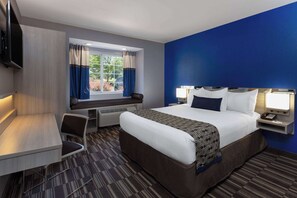 A hotel room with a bed, a desk, a chair, a TV, and a window with curtains. - Microtel Inn & Suites by Wyndham Bethel/Danbury (Bethel)