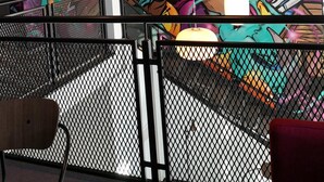 Een modern interieur met een levendige graffiti muurschildering, hangende pendelverlichting en een metalen leuning.