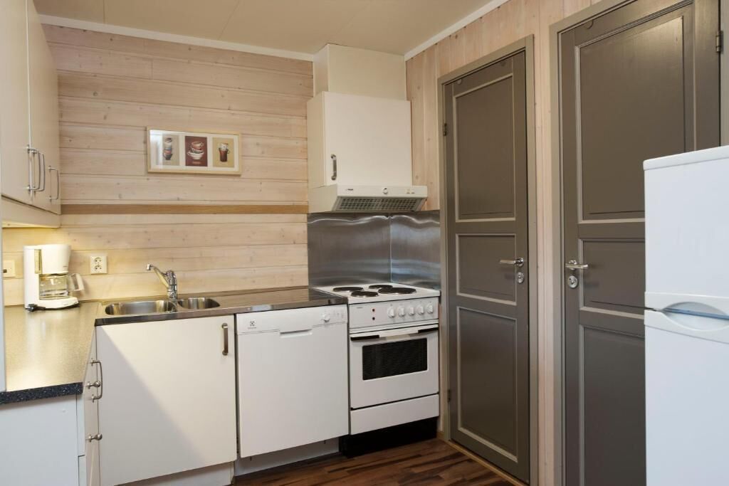 A compact kitchen with a gas stove, oven, and a refrigerator.