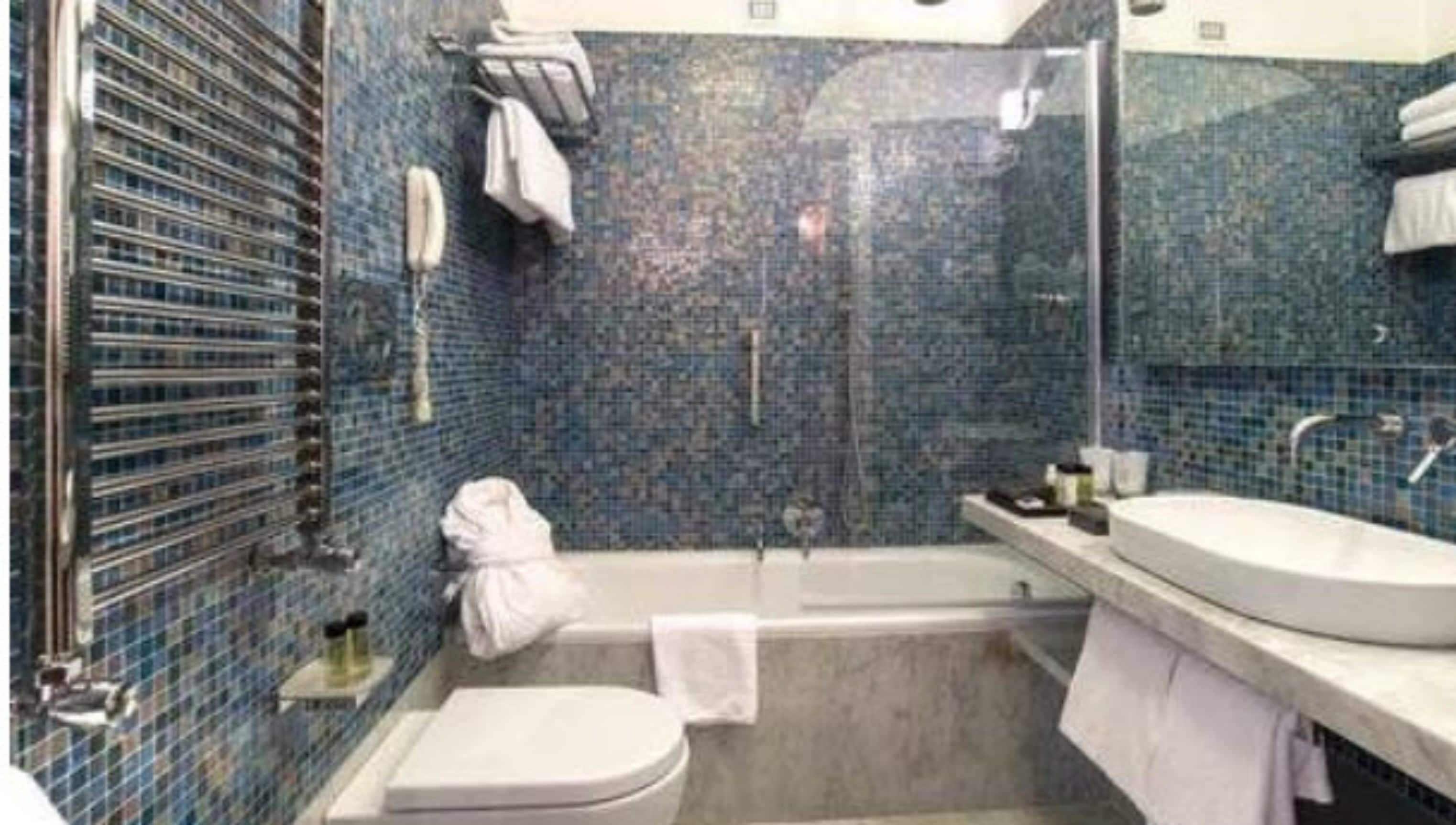 A bathroom with a bathtub, a toilet, and a sink.