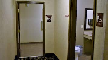 A hotel bathroom with a no smoking sign, a women's restroom sign, and a men's restroom sign.