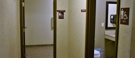 A hotel bathroom with a no smoking sign, a women's restroom sign, and a men's restroom sign.