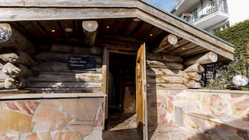 Ein Steinhaus mit einem Holzeingang und einem Schild, das eine Temperatur von 30°C anzeigt.