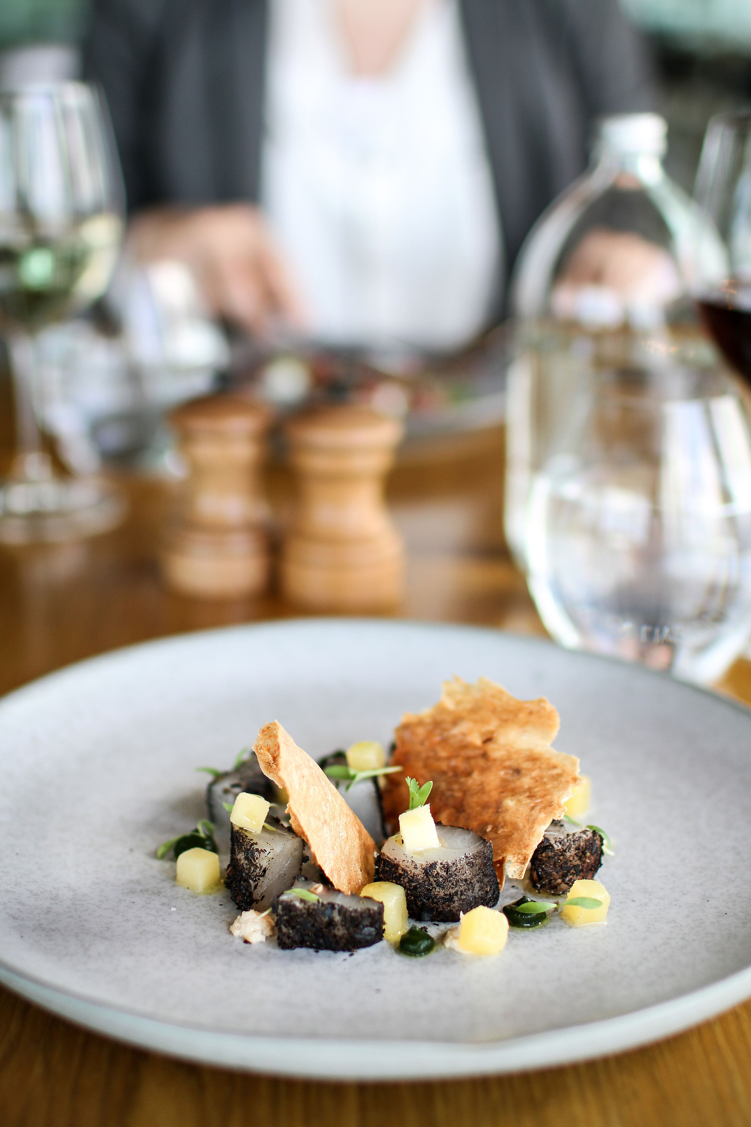 A plate of food with a variety of items including what appears to be a mushroom dish, garnished with herbs and possibly some diced vegetables.