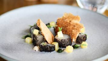 A plate of food with a variety of items including what appears to be a mushroom dish, garnished with herbs and possibly some diced vegetables.