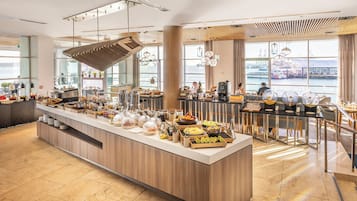 Ein modernes Frühstücksbuffet mit vielfältigen Speisen und Blick auf das Wasser.