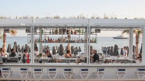Een bar met verschillende zitplaatsen en uitzicht op zee.