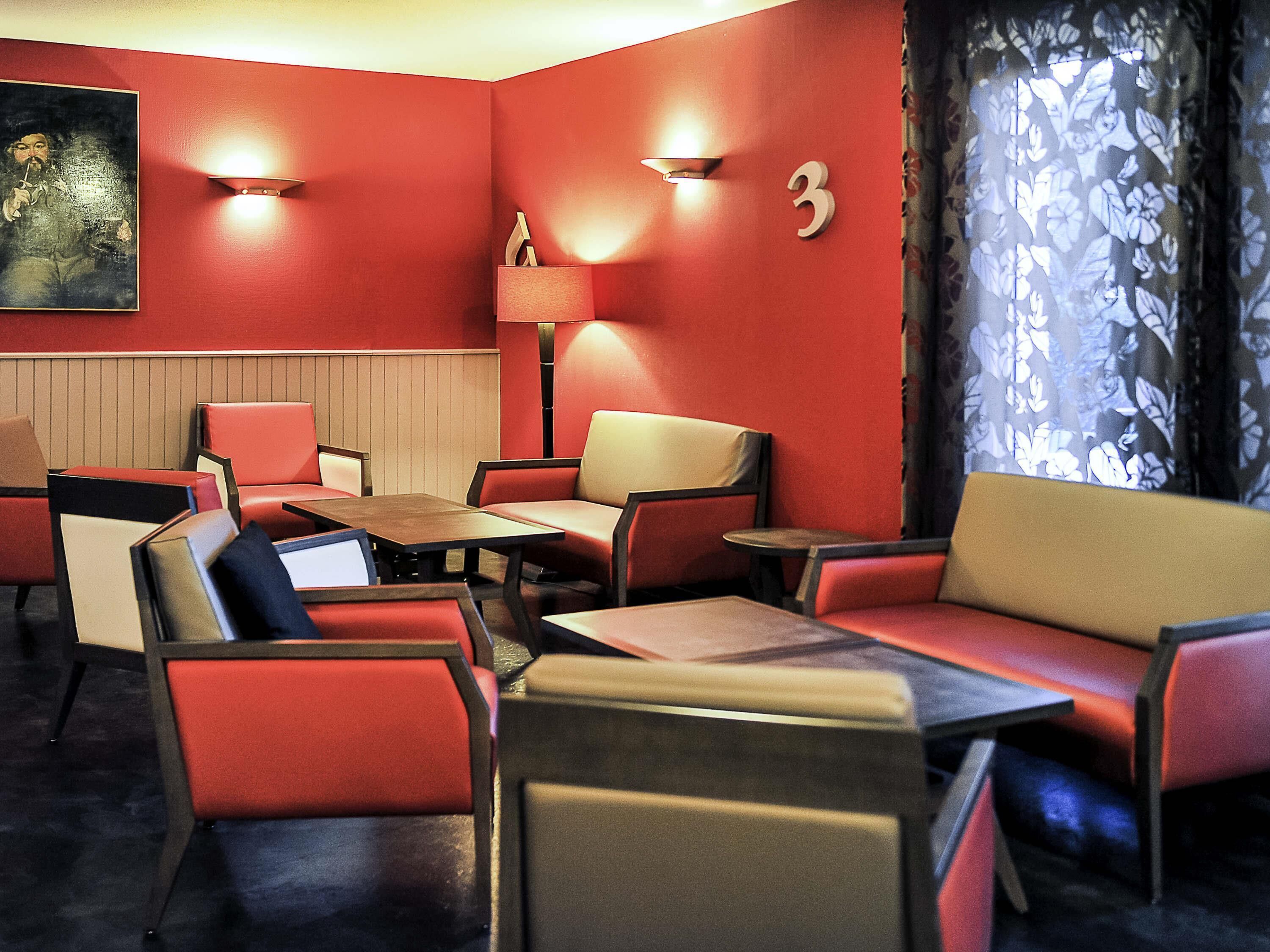 A room with red walls, a number '3' sign, a painting, and a patterned curtain.