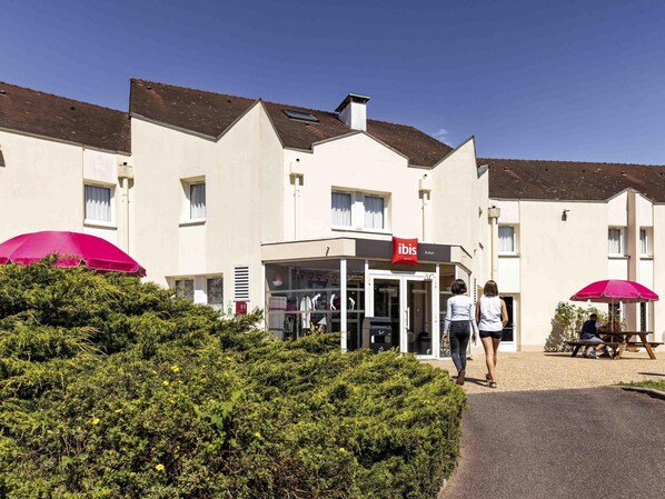 A hotel with a modern facade, a red ibis logo, and a welcoming entrance.