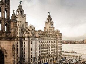 A large, historic building with multiple towers and a prominent clock tower.