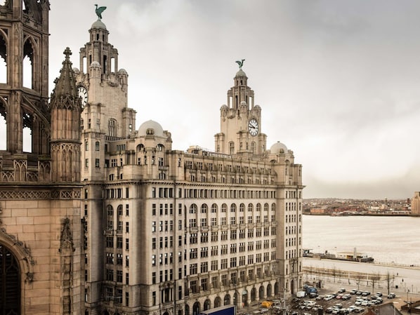 A large, historic building with multiple towers and a prominent clock tower.