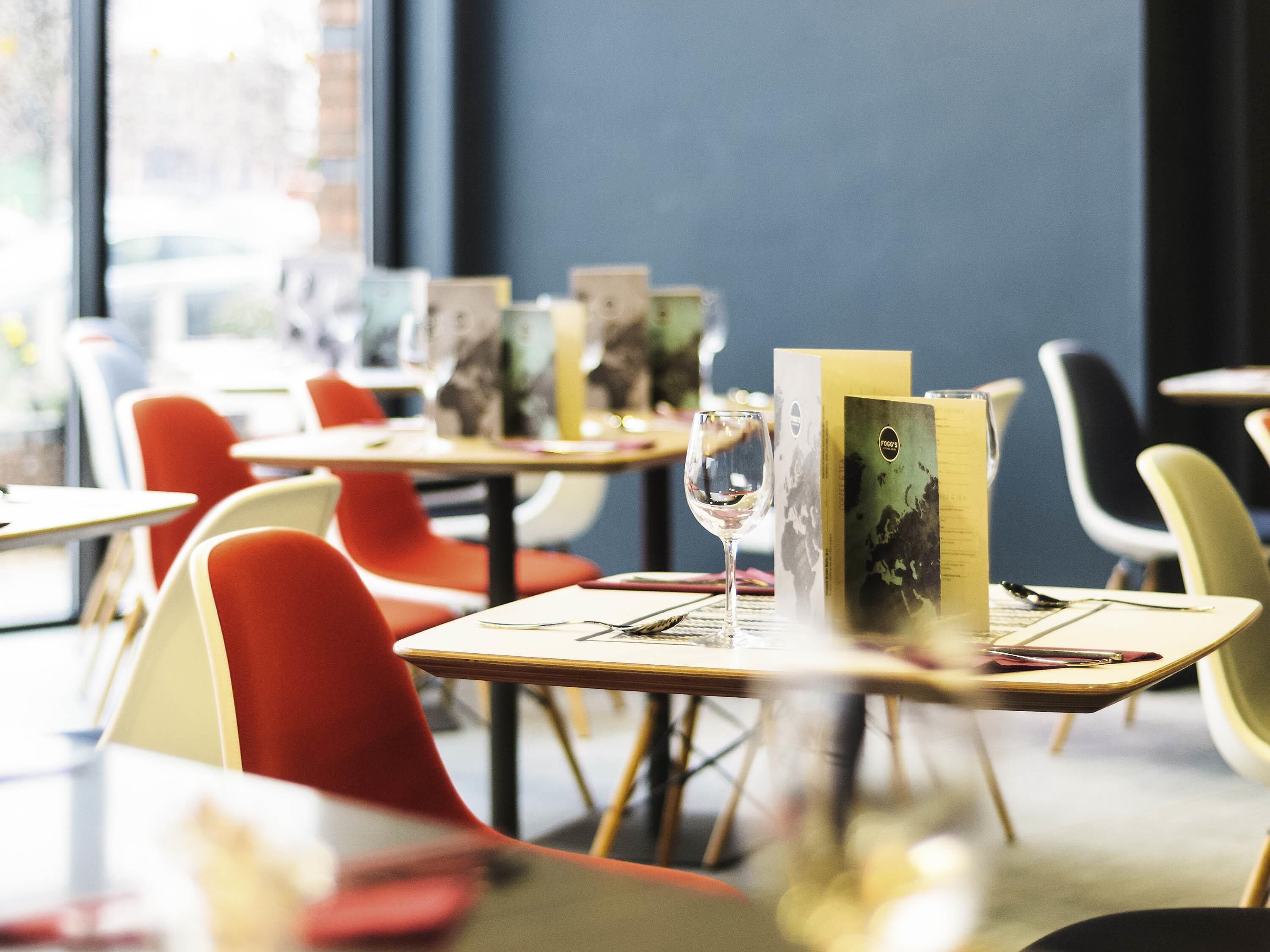 A restaurant interior with tables, chairs, and menus.