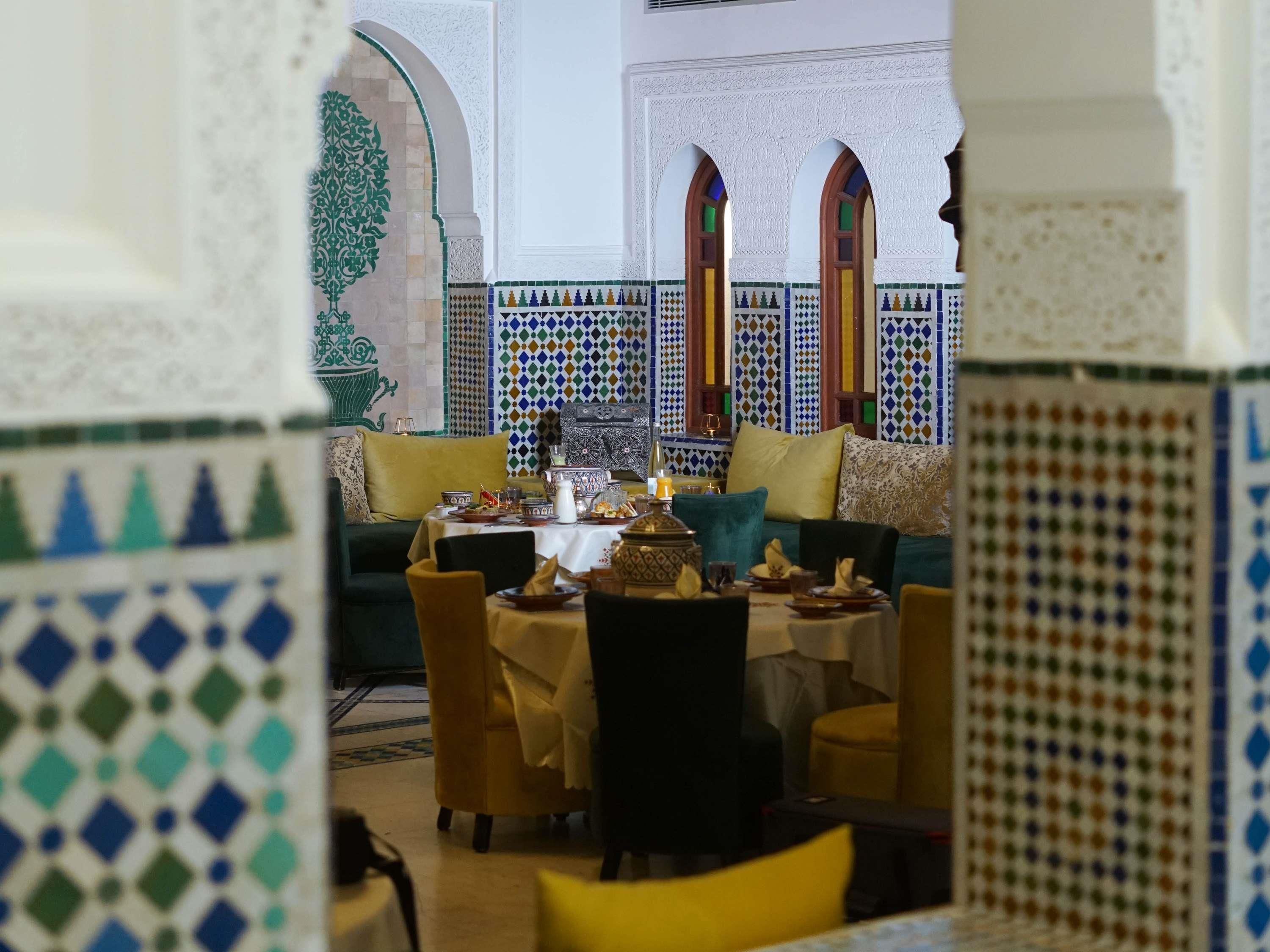 Un espace de salle à manger intérieur, avec une table dressée pour un repas, entourée de chaises.
