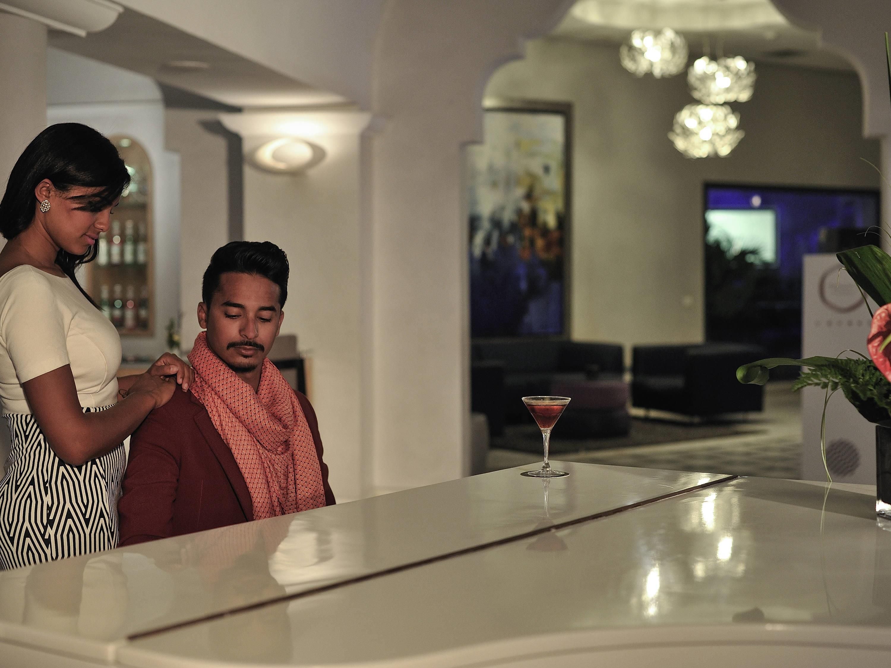 Un intérieur moderne avec un bar, des sièges et des œuvres d’art accrochées aux murs.