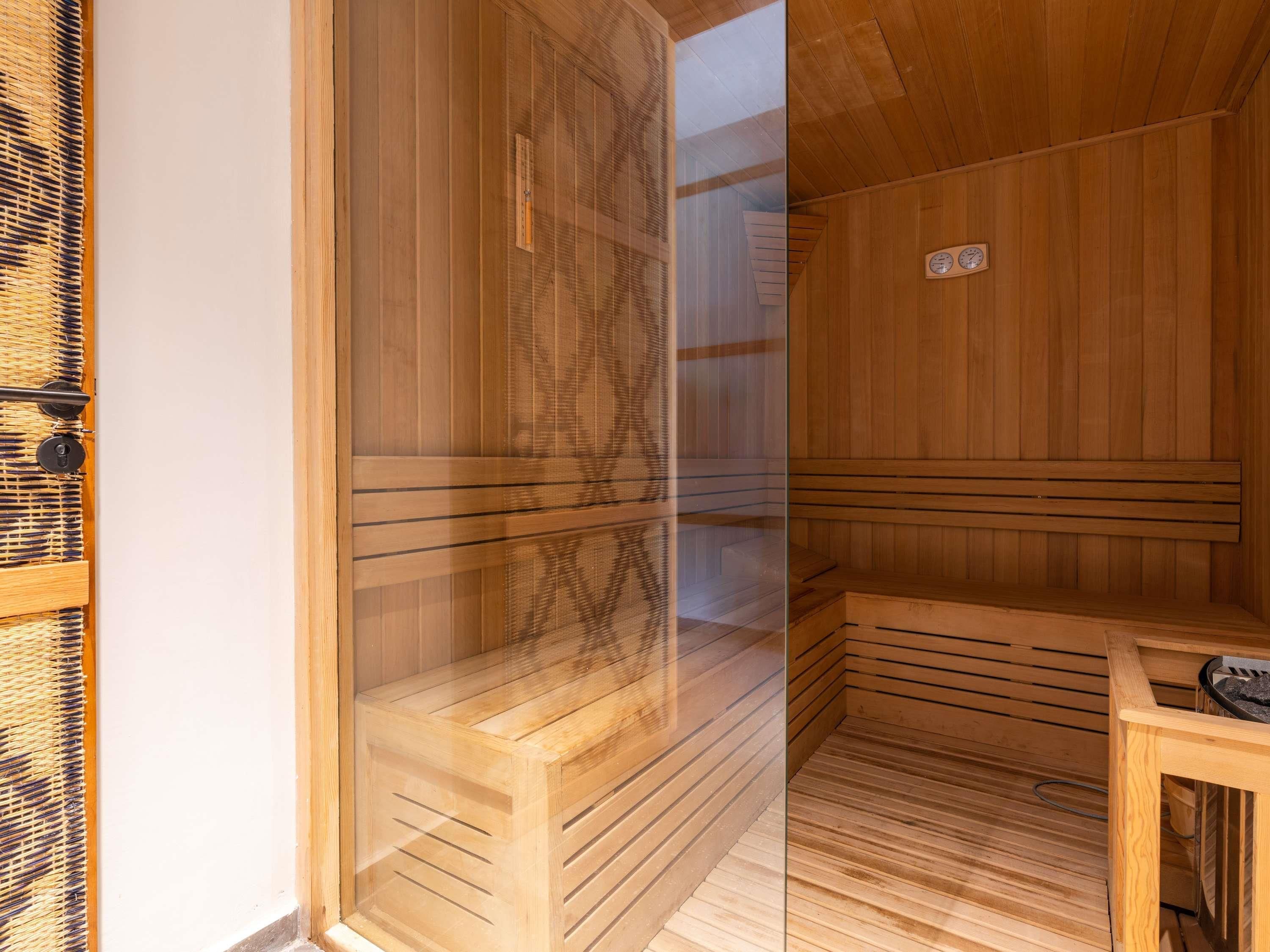 Una sauna con panche in legno e una panca con uno scaldabagno.