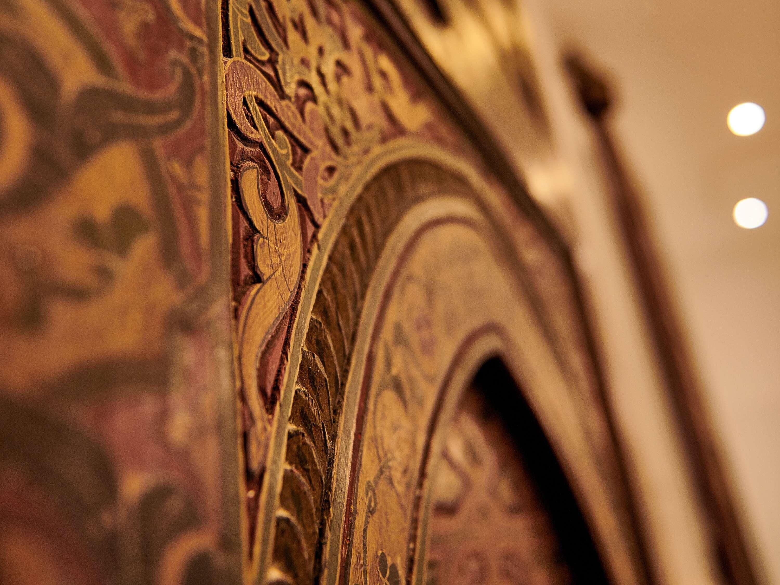 Detalle arquitectónico ornamentado con tallas intrincadas y un arco curvo.
