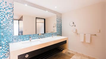 Un baño moderno con un espejo grande, dos lavamanos y un perchero para toallas.