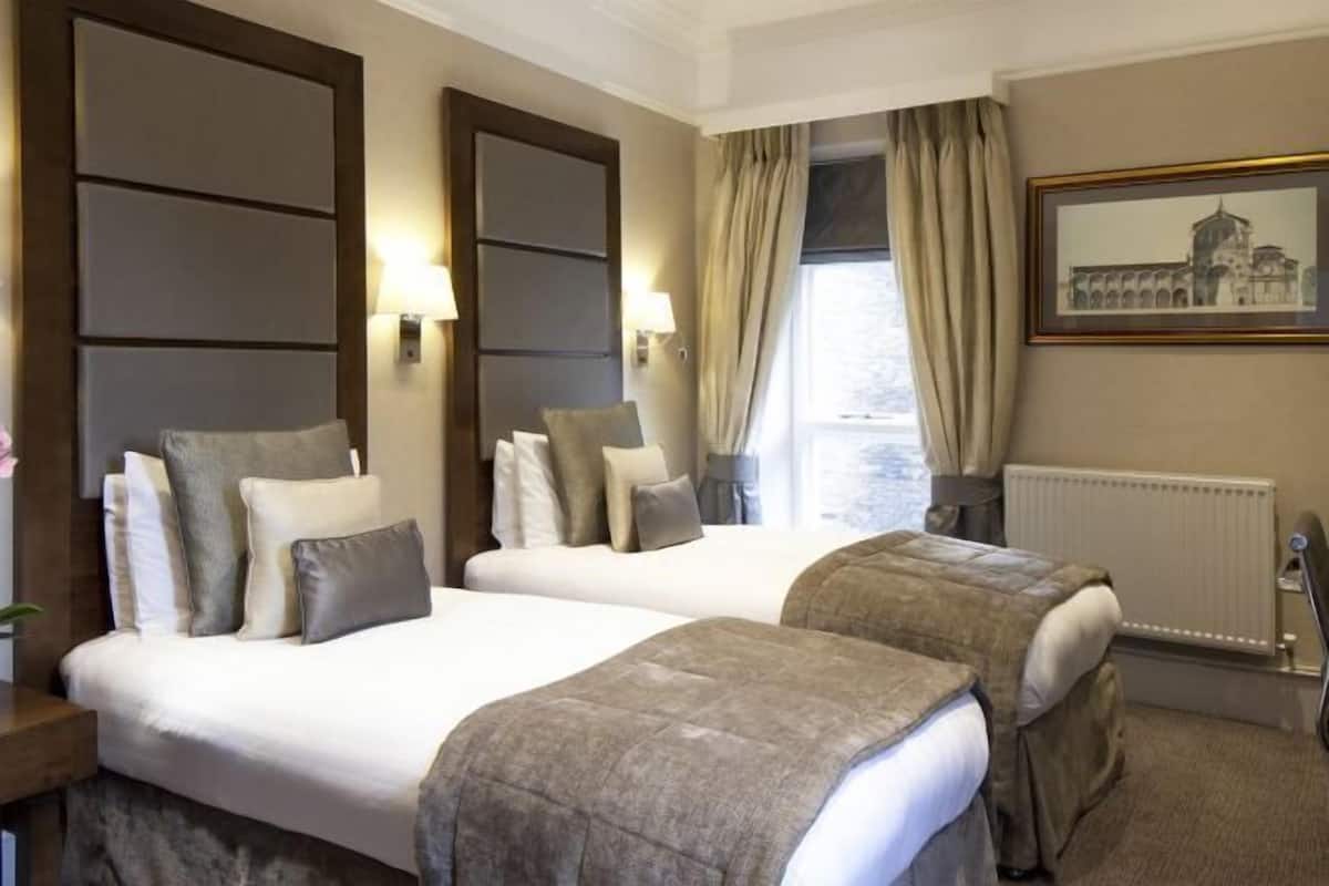 Ropa de cama hipoalergénica y caja de seguridad en la habitación