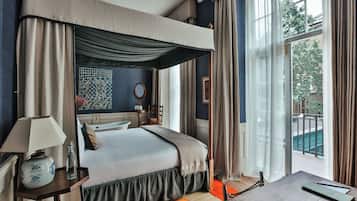 Une chambre d’hôtel avec un grand lit, une table de chevet avec une lampe, une fenêtre avec des rideaux et une vue sur l’extérieur.