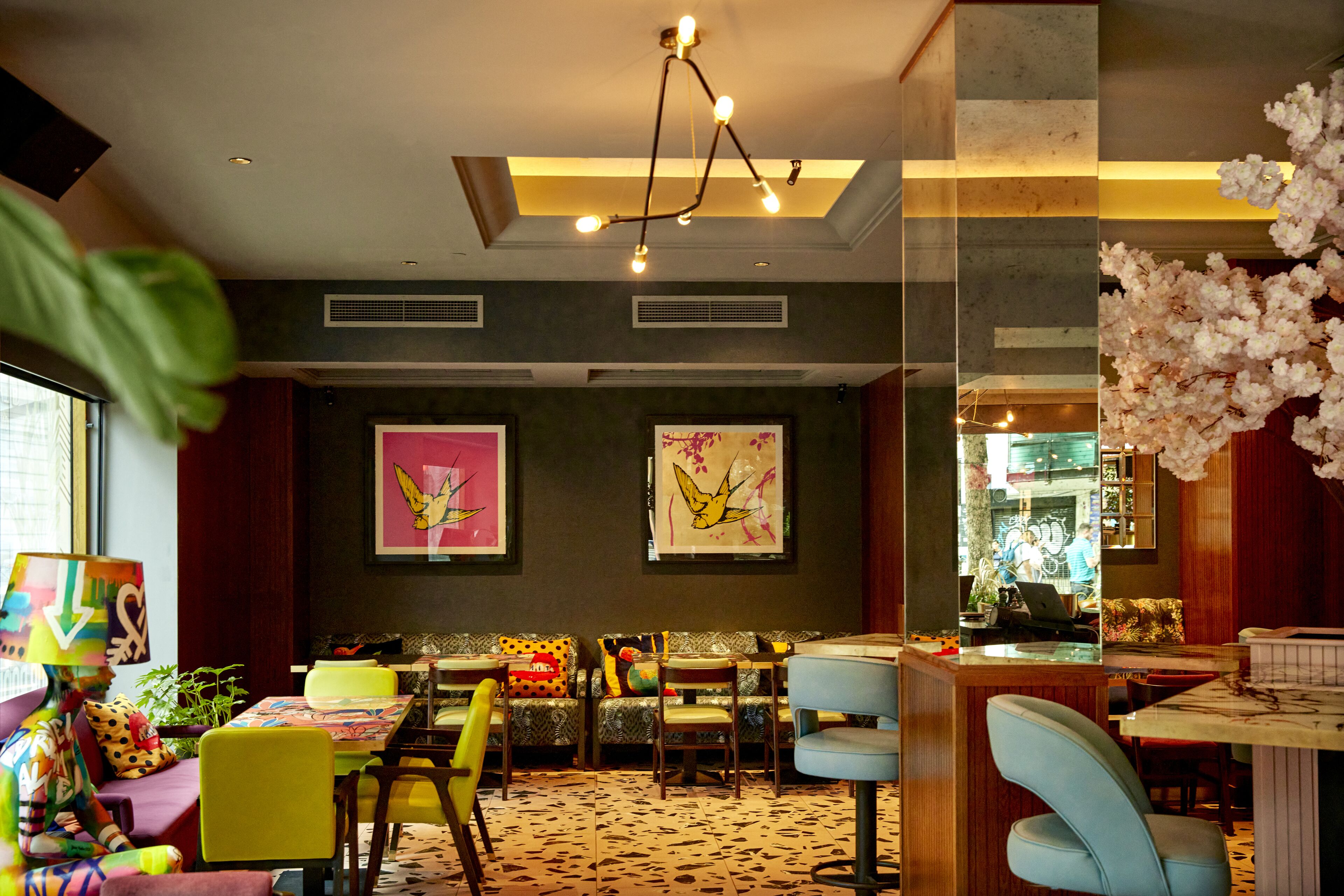 Un interior moderno con comedor, sillas coloridas y obras de arte en las paredes.