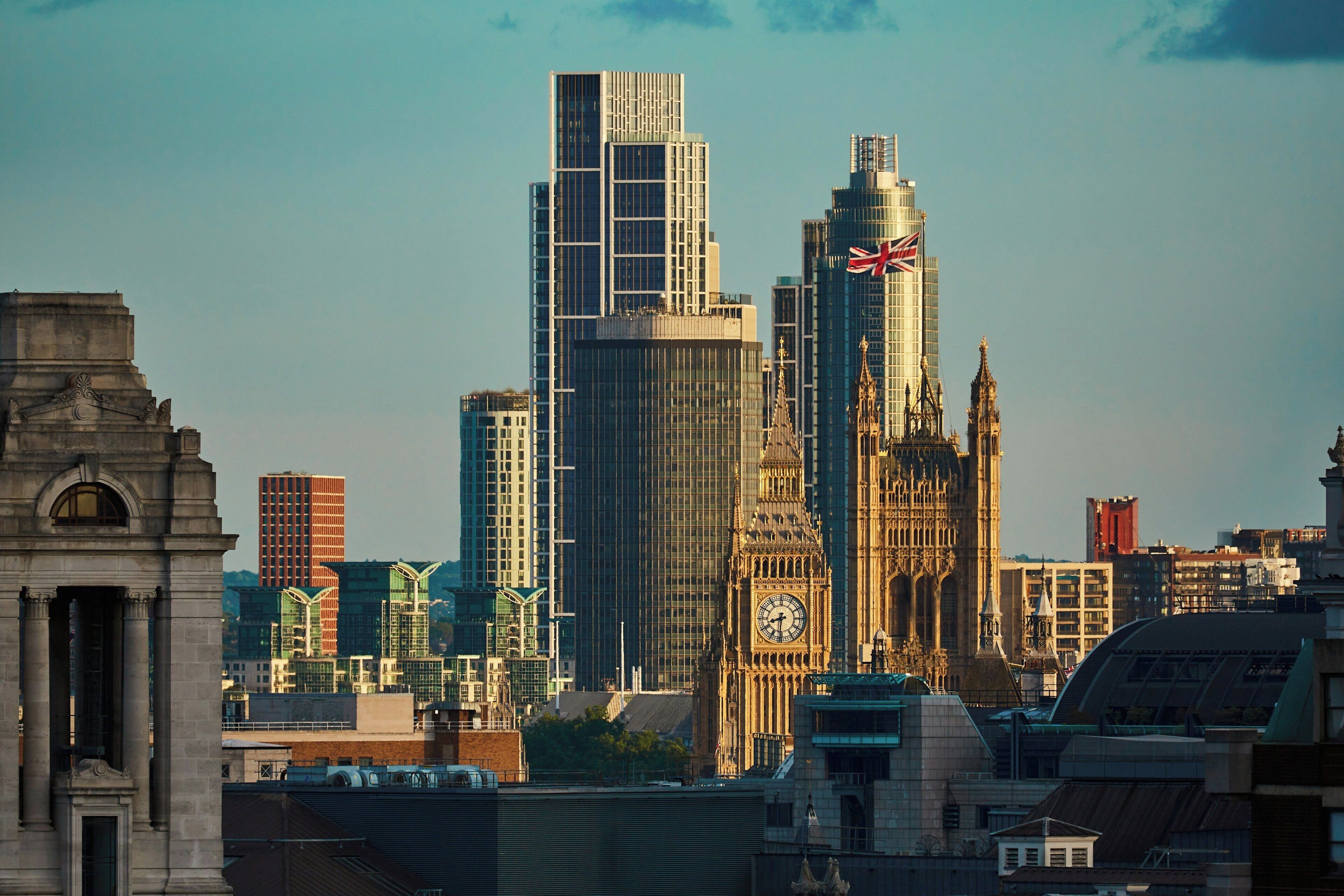A cityscape with modern skyscrapers and the iconic Big Ben clock tower.