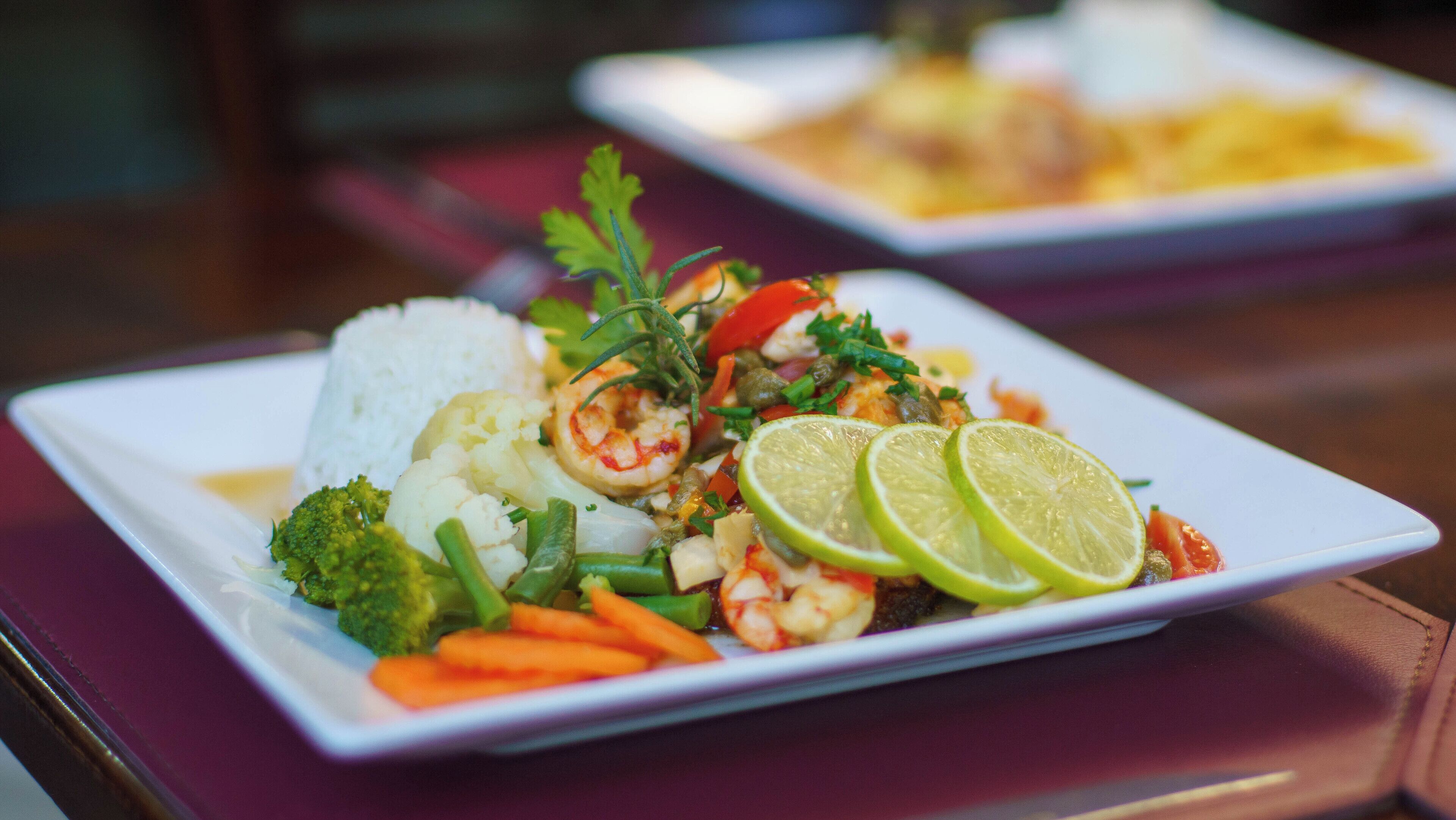 A plate of food with rice, vegetables, and shrimp.
