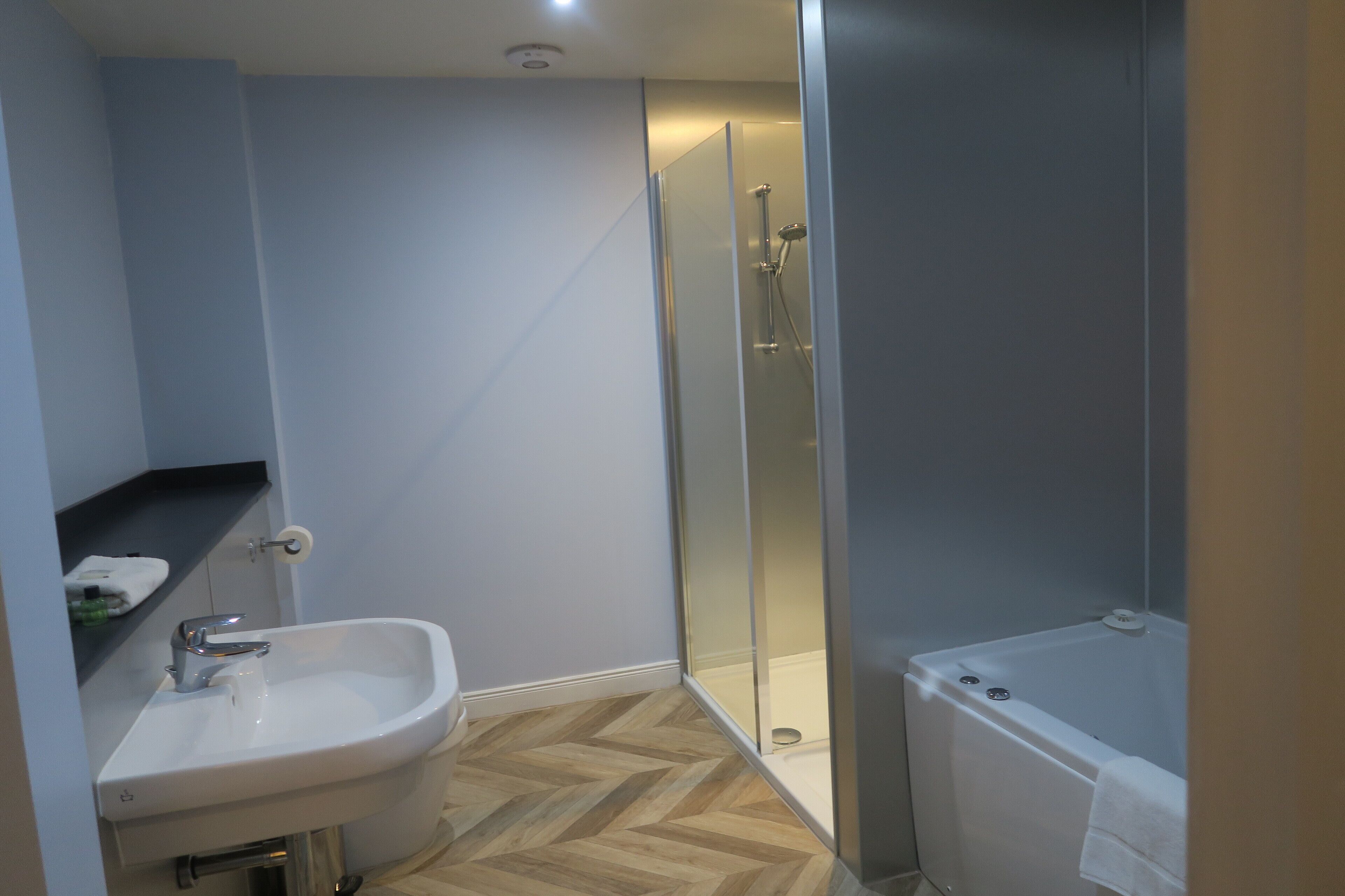 A modern bathroom with a sink, toilet, shower, and bathtub.