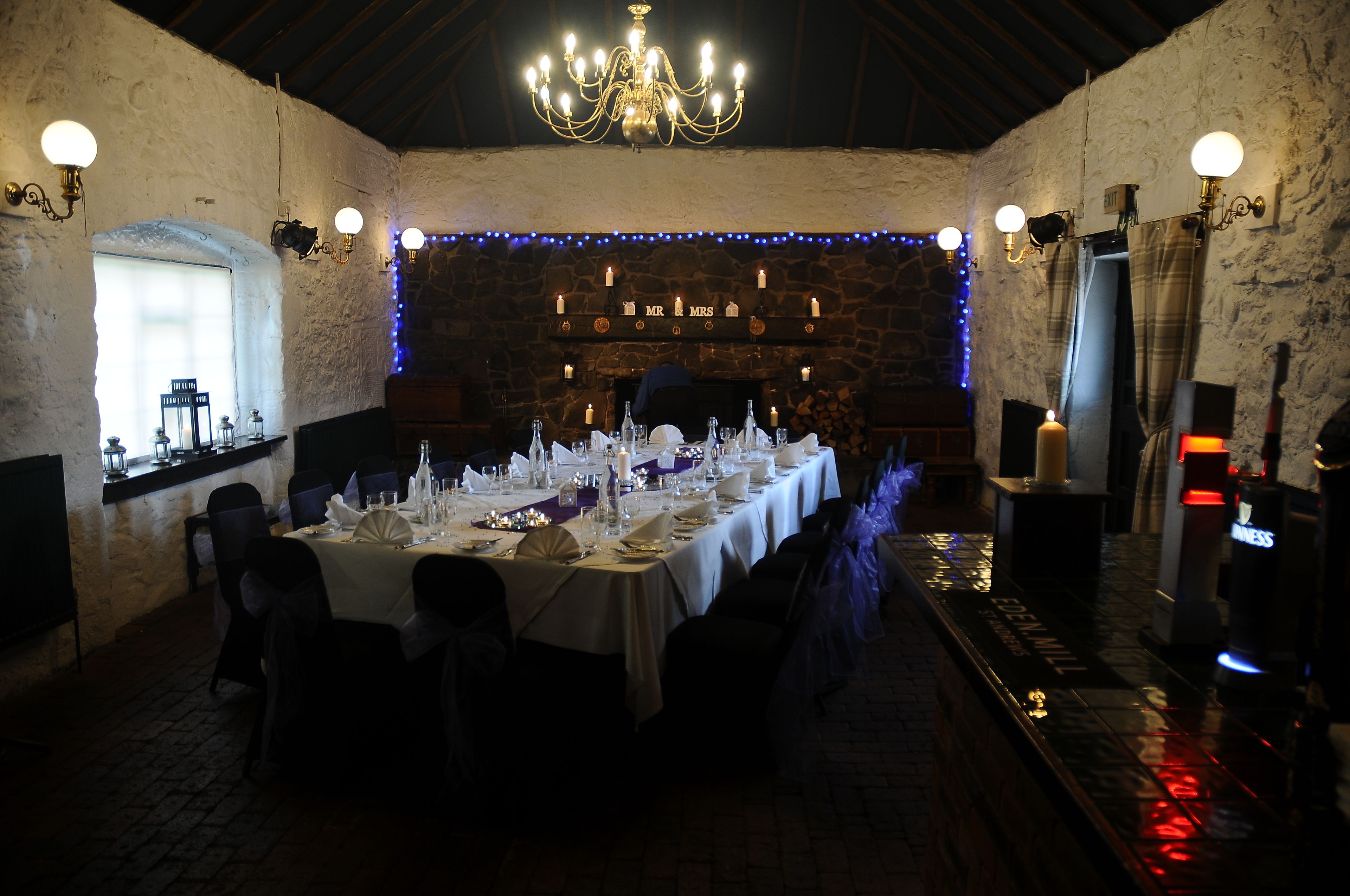A long dining table set for a formal event, with candles and tableware.