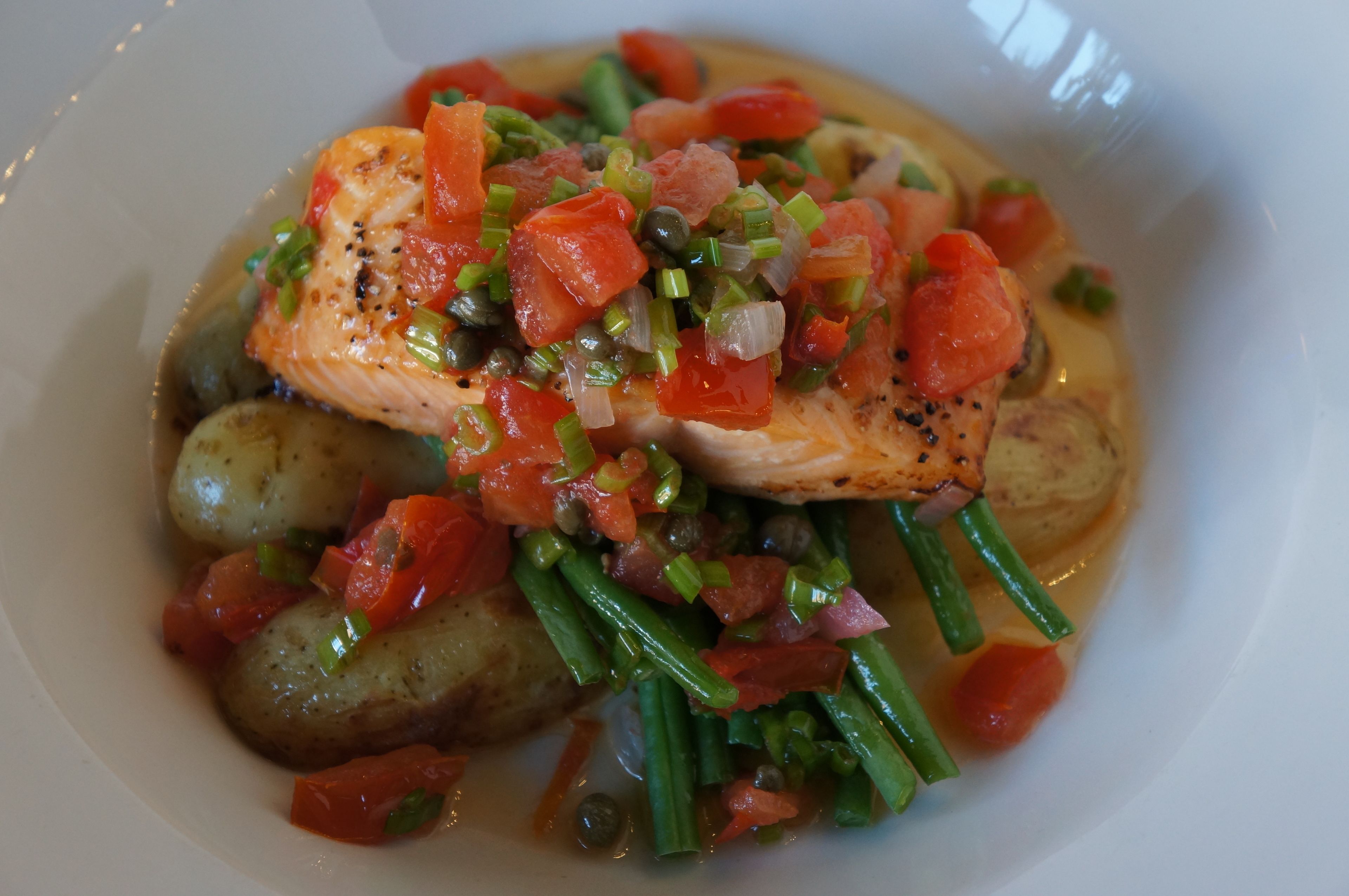 A dish with salmon, potatoes, and green beans.