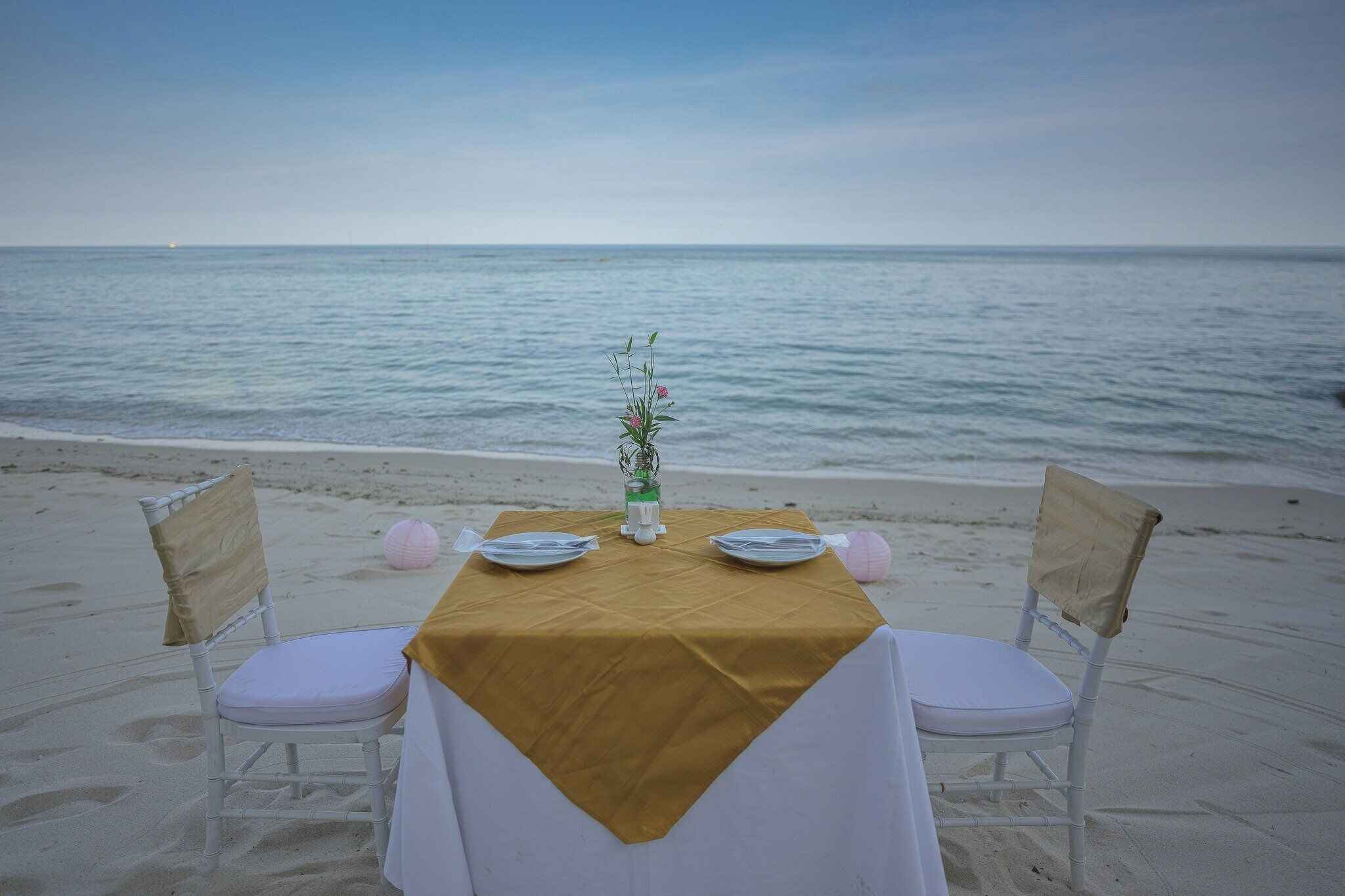 A table set on a beach with a view of the sea.
