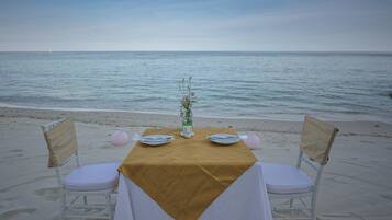 A table set on a beach with a view of the sea.