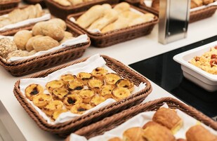 Buffet com diversas opções de pães, doces e bolachas.