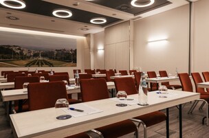 Ein Konferenzraum mit Tischen, Stühlen und Wasserflaschen.